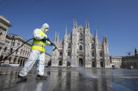 A worker sprays disinfectant to sanitize Duomo square, as the city main landmark, the gothic cathedral, stands out in background, in Milan, Italy, Tuesday, March 31, 2020. The new coronavirus causes mild or moderate symptoms for most people, but for some, especially older adults and people with existing health problems, it can cause more severe illness or death. (AP Photo/Luca Bruno)