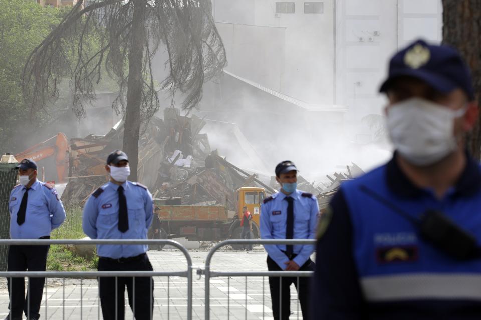 Police guard during the demolition of the national theater building in Tirana, Sunday, May 17, 2020. The government's decision to destroy the old National Theater, built by Italians when they occupied Albania during World War II, was opposed by artists and others who wanted it renovated instead. (AP Photo/Gent Onuzi)