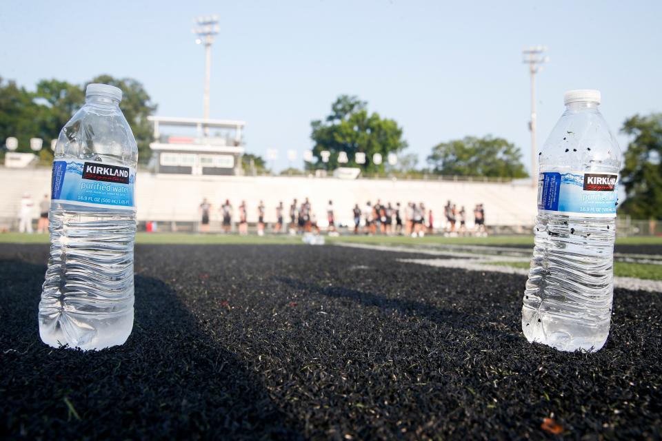 Two water bottles are seen on the field as football players take a water break during practice at Houston High School in Germantown, Tenn., on Monday. Germantown residents are still being advised not to drink the city’s tap water after it was contaminated with diesel fuel.