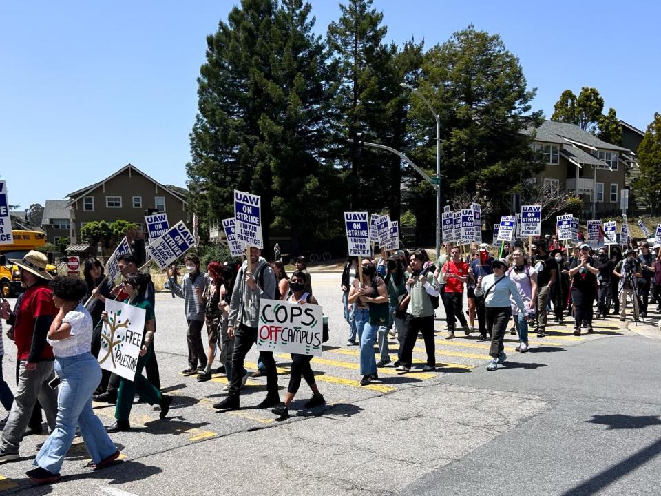 Striking workers picket with signs, including "Cops Off Campus."