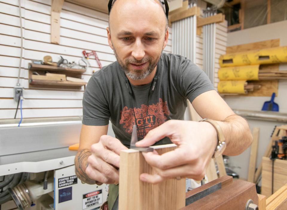 Woodworker Garrett Roberson scribes lines in part of a drawer as guides to dovetail joints he cuts by hand on Monday, Nov. 21, 2022. Roberson is making custom furniture using lumber from a felled tree on the McPherson Mansion property, and the furniture will go in a conference room in that building.