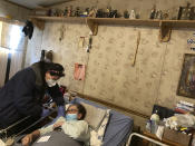 Mora County Ambulance Service Director Brenda Casados makes a home visit to administer a COVID-19 vaccine shot to 71-year-old Amalia Montoya in Cleveland, N.M., on Tuesday, April 20, 2021. New Mexico is among the states with the highest rates of vaccination for COVID-19 and efforts are underway to respond to skepticism and misinformation about the effectiveness and risks of immunization. First Lady Jill Biden was kicking off of a visit to the U.S. Southwest with a tour of a vaccination clinic in Albuquerque. (AP Photo/Morgan Lee)