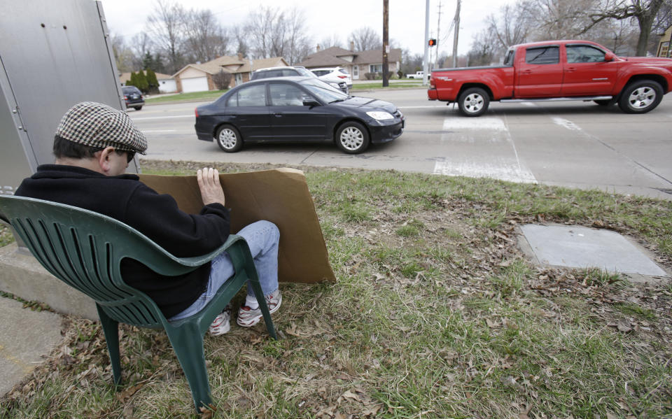 Edmond Aviv sits on a street corner holding a sign Sunday, April 13, 2014, in South Euclid, Ohio declaring he's a bully, a requirement of his sentence because he was accused of harassing a neighbor and her disabled children for the past 15 years. Municipal Court Judge Gayle Williams-Byers ordered Aviv, 62, to display the sign for five hours Sunday. It says: "I AM A BULLY! I pick on children that are disabled, and I am intolerant of those that are different from myself. My actions do not reflect an appreciation for the diverse South Euclid community that I live in." (AP Photo/Tony Dejak)