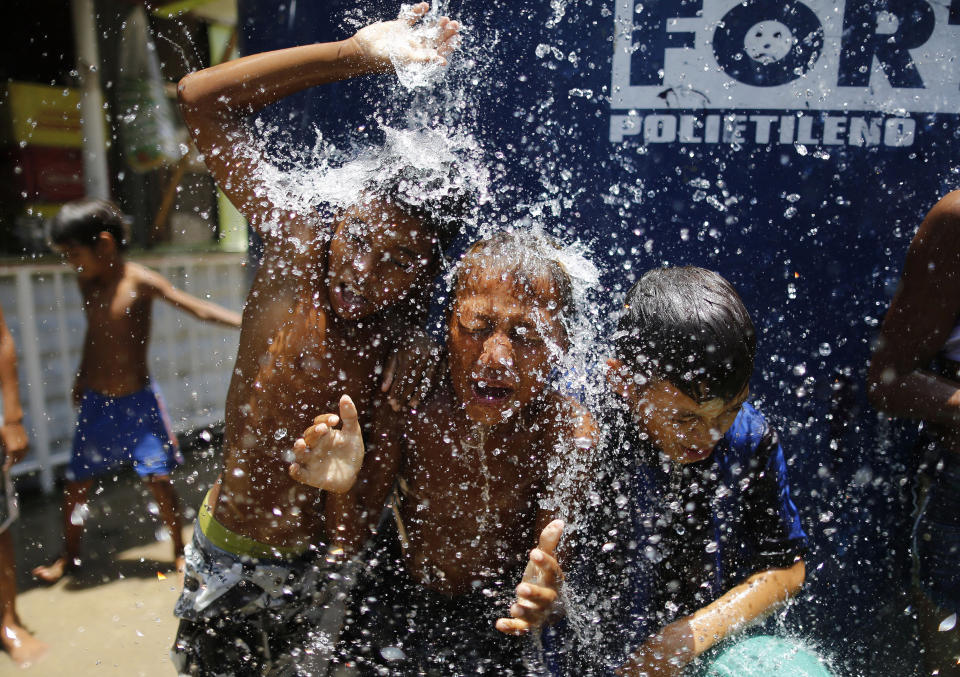 Children play under the water from a water tank at the Alemao Complex neighborhood in Rio de Janeiro in January 2015. According to state environment secretary Andre Correa, the region was &ldquo;experiencing the worst water crisis in its history.&rdquo; (Photo: AP Photo/Leo Correa)