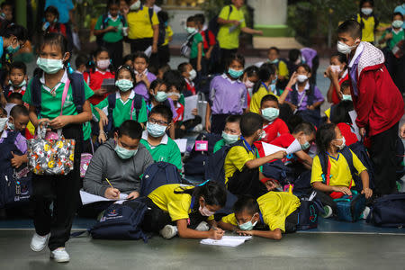 Student wear masks as they wait to be picked up, as classes in over 400 Bangkok schools have been cancelled due to worsening air pollution, at a public school in Bangkok, Thailand, January 30, 2019. REUTERS/Athit Perawongmetha