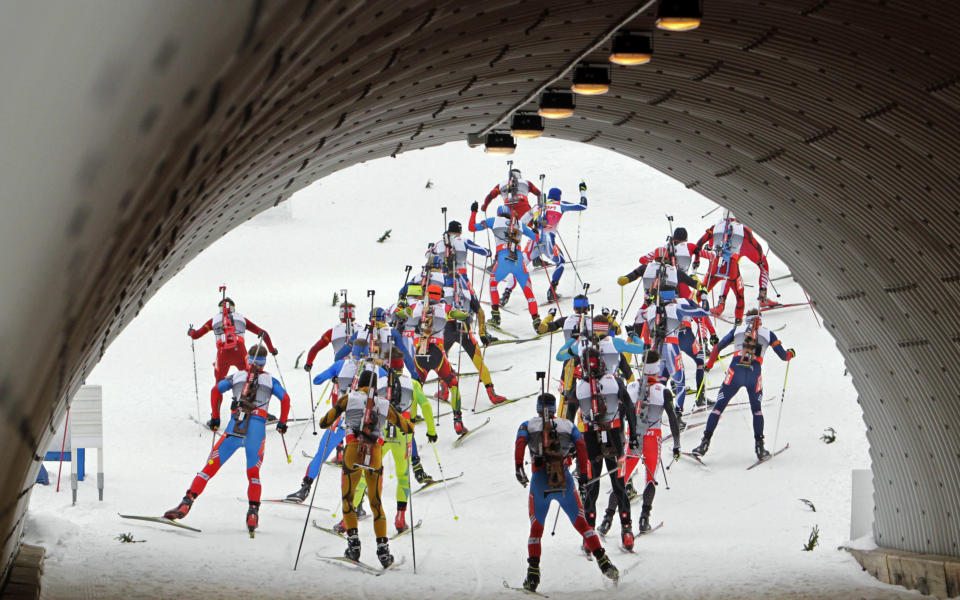 Biathletes exit a tunnel as they compete in the men's 15 km mass start race during the International Biathlon Union (IBU) World Championships in Nove Mesto February 17, 2013. REUTERS/David W Cerny (CZECH REPUBLIC - Tags: SPORT BIATHLON) - RTR3DWYZ