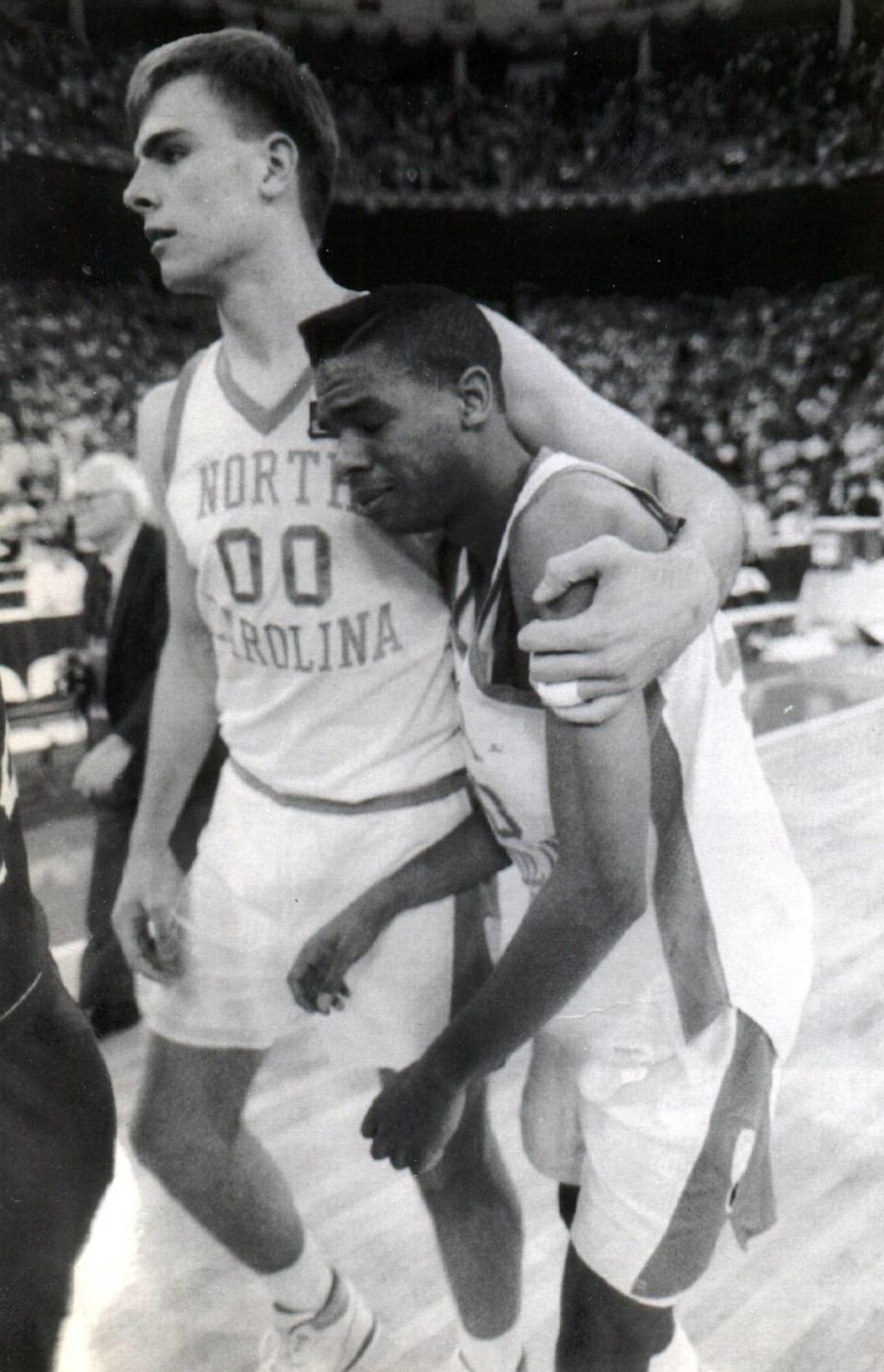 UNC’s Hubert Davis, right, is consoled by teammate Eric Montross after the Tarheels were defeated by the Kansas Jayhawks in the semifinals of the NCAA tournament at the Hoosier Dome March 30, 1991. Jeff Siner/jsiner@charlotteobserver.com