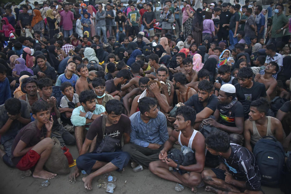 Newly-arrived ethnic Rohingya people sit on the beach after disembarking from their boat in Ulee Madon, North Aceh, Indonesia, Thursday, Nov. 16, 2023. Some 240 Rohingya Muslims, including women and children, are afloat off the coast of Indonesia after two attempts to land were rejected by local residents. The boat left again a few hours later following the rejection. (AP Photo/Rahmat Mirza)