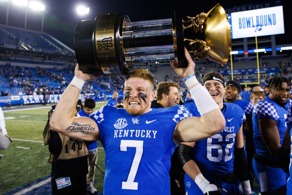 Kentucky Wildcats quarterback Will Levis (7) holds up the Governor’s Cup trophy after winning the game against the Louisville Cardinals at Kroger Field.