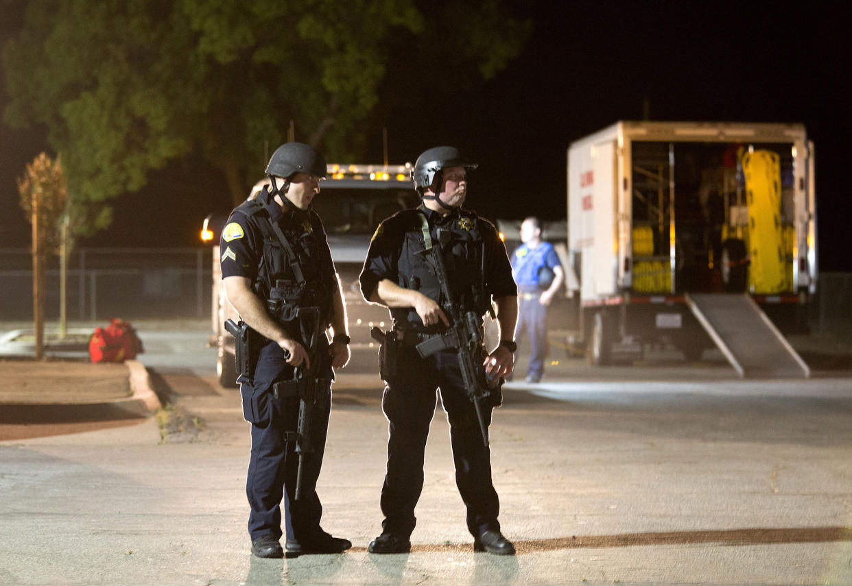 Police officers dressed in SWAT gear stand guard at the first aid center at Gilroy High School following a shooting at the Gilroy Garlic Festival in California (Picture: AP)