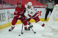 Detroit Red Wings center Luke Glendening (41) and Carolina Hurricanes right wing Sebastian Aho (20) battle for the puck in the second period of an NHL hockey game Thursday, Jan. 14, 2021, in Detroit. (AP Photo/Paul Sancya)