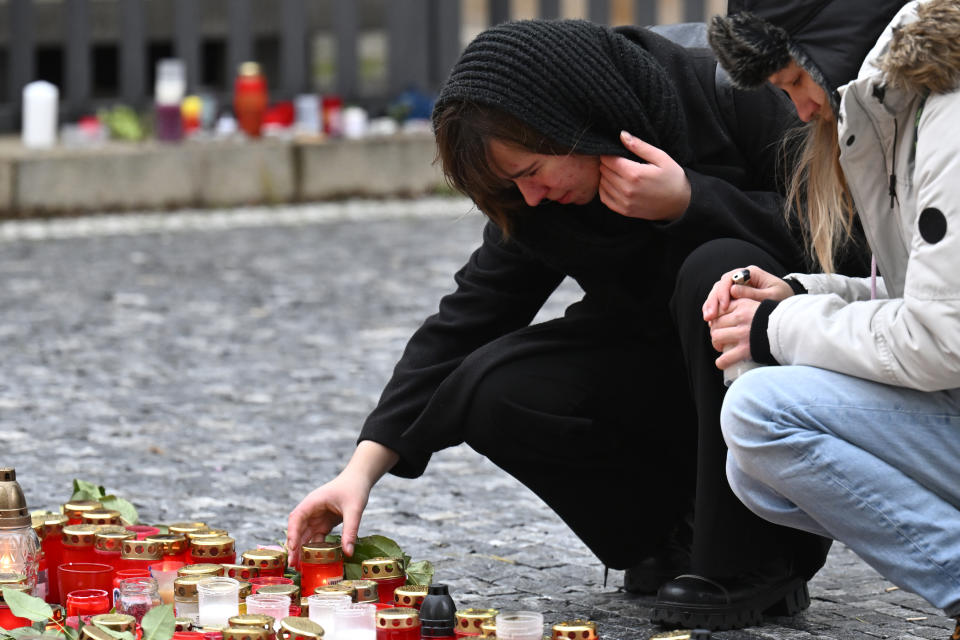 Young people leave a candle outside the headquarters of Charles University in downtown Prague, Czech Republic, Saturday, Dec. 23, 2023. A lone gunman opened fire at a university on Thursday, killing over 12 people and injuring dozens. (AP Photo/Denes Erdos)