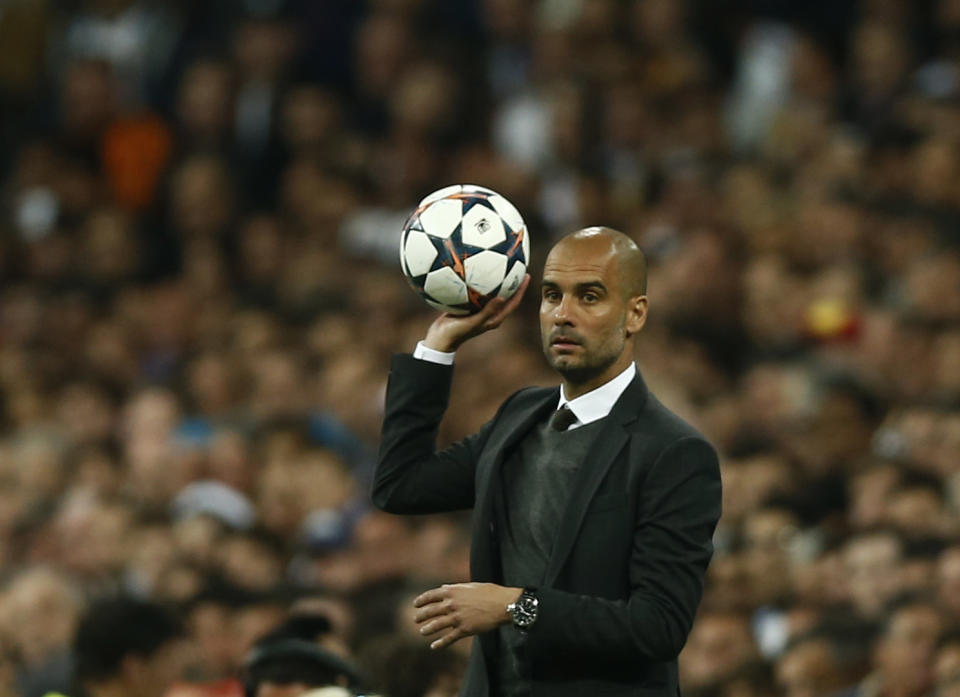 El técnico del Bayern Munich Pep Guardiola retiene la pelota durante el partido ante Real Madrid por las semifinales de la Liga de Campeones el miércoles 23 de abril de 2014. (AP Foto/Andres Kudacki)