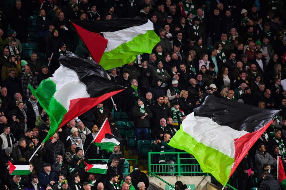 Supporters hold Palestinian flags at Celtic Park (AFP via Getty Images)