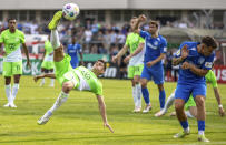 Wolfsburg's Joakim Maehle, left, attempts on goal during the German Soccer Cup match between TuS Makkabi and VfL Wolfsburg at Mommsenstadion stadium, Berlin, Sunday Aug. 13, 2023. (Andreas Gora/dpa via AP)