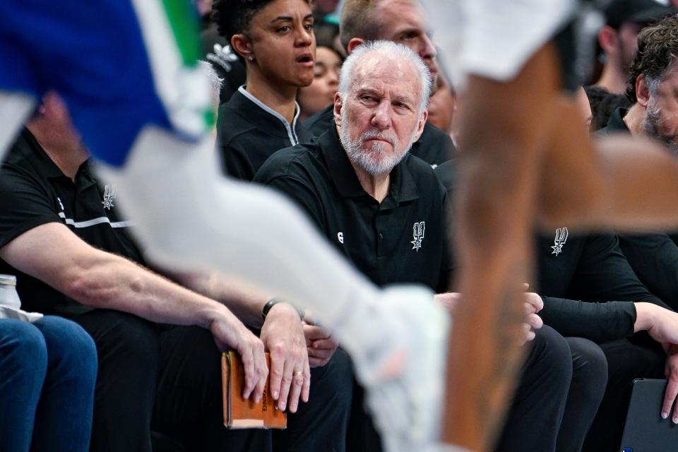 Gregg Popovich watches the San Antonio Spurs' regular-season finale against the Dallas Mavericks at the American Airlines Center.