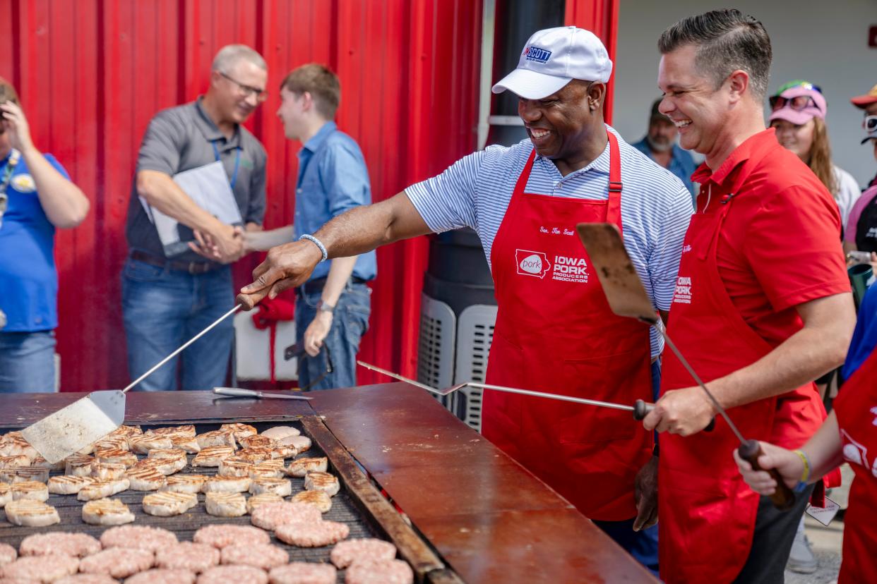 Sen. Tim Scott, R-S.C., left, works the grill outside the Iowa Pork Producers tent with Rep. Zach Nunn, R-Iowa, at the Iowa State Fair.