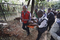 An injured woman is carried away by paramedics at a hotel complex in Nairobi, Kenya Tuesday, Jan. 15, 2019. Terrorists attacked an upscale hotel complex in Kenya's capital Tuesday, sending people fleeing in panic as explosions and heavy gunfire reverberated through the neighborhood. (AP Photo/Ben Curtis)