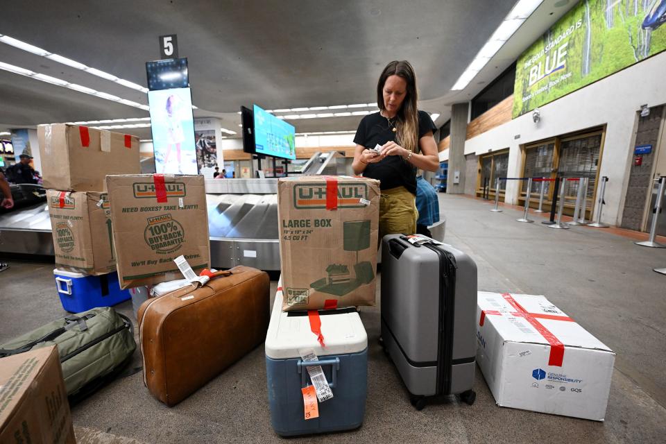 Lindsay Hughes sorts the tracking numbers for all the boxes and suitcases at the Kahului Airport that she and her husband, T, brought back from the mainland to Kihei, Hawaii, on Wednesday, Aug. 16, 2023. Response to the Maui fire that destroyed a large portion of the town of Lahaina continues from neighboring islands and the mainland. | Scott G Winterton, Deseret News