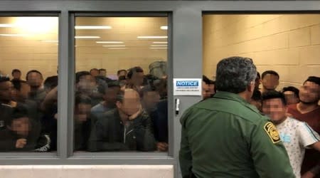 FILE PHOTO: Men are crowded in a room at a Border Patrol station in a still image from video in McAllen