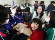 Evacuated children play a card game at a shelter in Sendai city in Miyagi prefecture. Japan's government has warned that panic buying could hurt its ability to provide aid to areas devastated by Friday's natural disaster, which has left 3,373 confirmed dead. Many thousands more are still missing