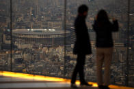 Japan National Stadium, where opening ceremony and many other events are planned for postponed Tokyo 2020 Olympics, is seen from a rooftop observation deck Thursday, Jan. 21, 2021, in Tokyo. The postponed Tokyo Olympics are to open in just six months. Local organizers and the International Olympic Committee say they will go ahead on July 23. But it’s still unclear how this will happen with virus cases surging in Tokyo and elsewhere around the globe. (AP Photo/Kiichiro Sato)