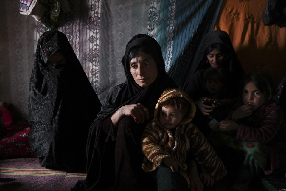 Guldasta and family members gather in their house at a settlement near Qala-e-Naw, Afghanistan, Dec. 14, 2021. Guldasta, said that after days with nothing to eat, she told her husband to take their 8-year-old son Salahuddin to the bazaar and sell him to bring food for the others. Afghanistan’s destitute are increasingly turning to such desperate decisions as the country spirals downwards into a vortex of poverty. (AP Photo/Mstyslav Chernov)