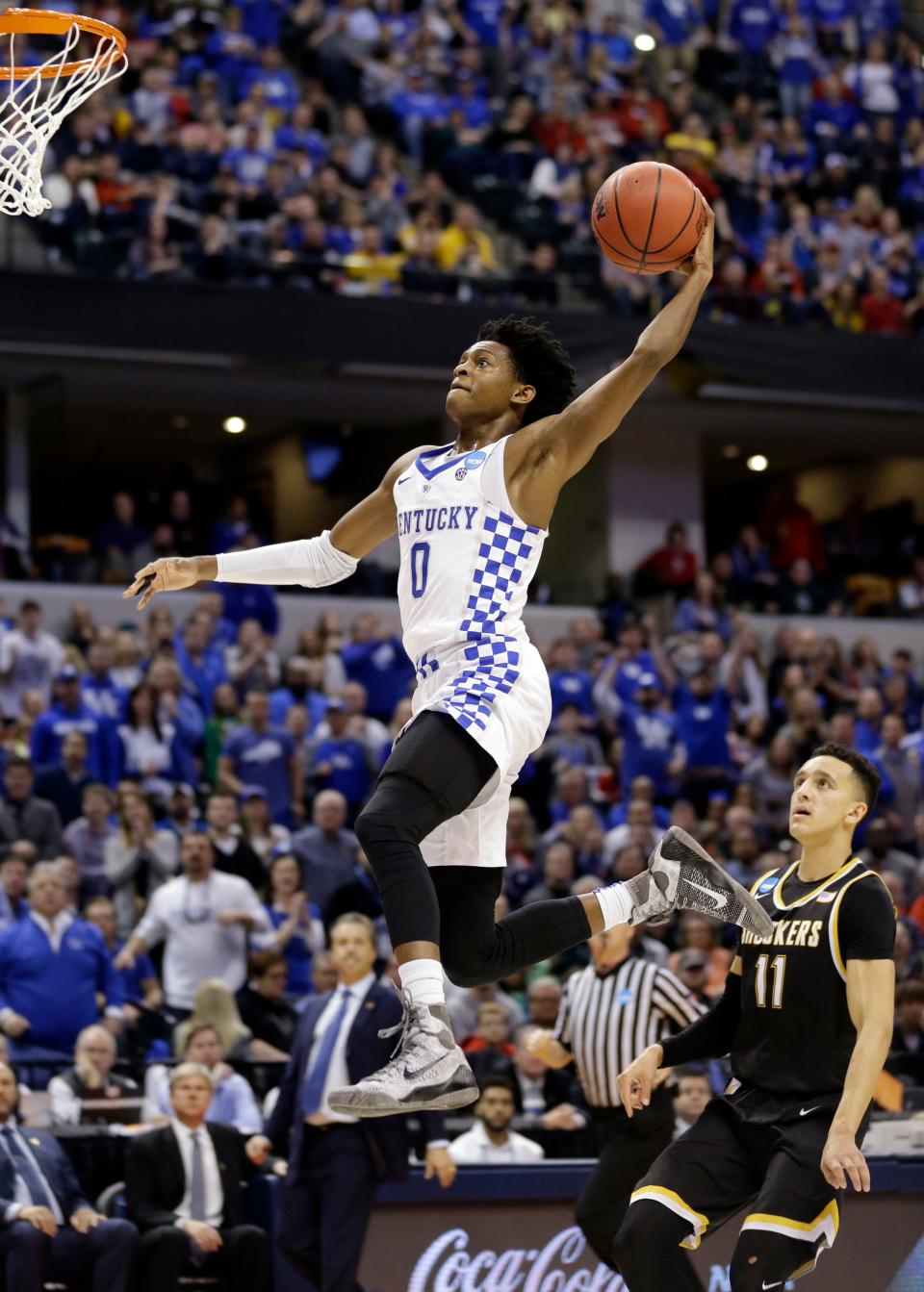 FILE - In this March 19, 2017, file photo, Kentucky guard De'Aaron Fox (0) goes up for a dunk in front of Wichita State guard Landry Shamet (11) during the second half of a second-round game in the men's NCAA college basketball tournament,  in Indianapolis. Fox is expected to be a picked at the NBA Draft. (AP Photo/Michael Conroy, File)