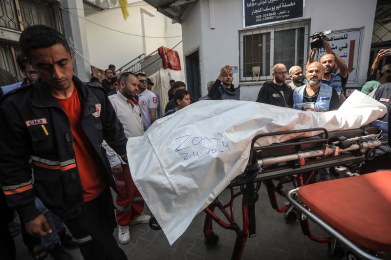 One of the bodies of staff members of the U.S.-based aid group World Central Kitchen is transported out of a hospital morgue in Rafah in the southern Gaza Strip on Wednesday. Photo by Ismael Mohamad/UPI