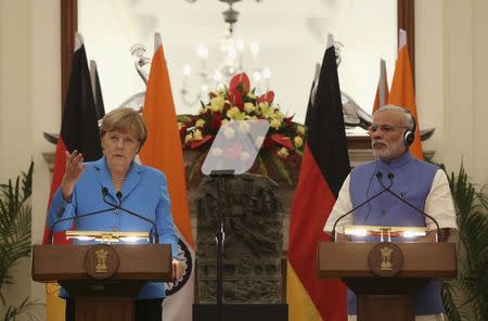 German Chancellor Merkel reads a joint statement next to India’s Prime Minister Modi after their delegation-level talks at Hyderabad House in New Delhi