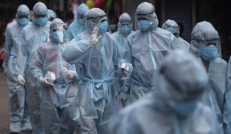 India health workers wearing personal protective equipment arrive to take part in a check up camp in a slum in Mumbai, India, Wednesday, June 17, 2020. India is the fourth hardest-hit country by the COVID-19 pandemic in the world after the U.S., Russia and Brazil. (AP Photo/Rafiq Maqbool)