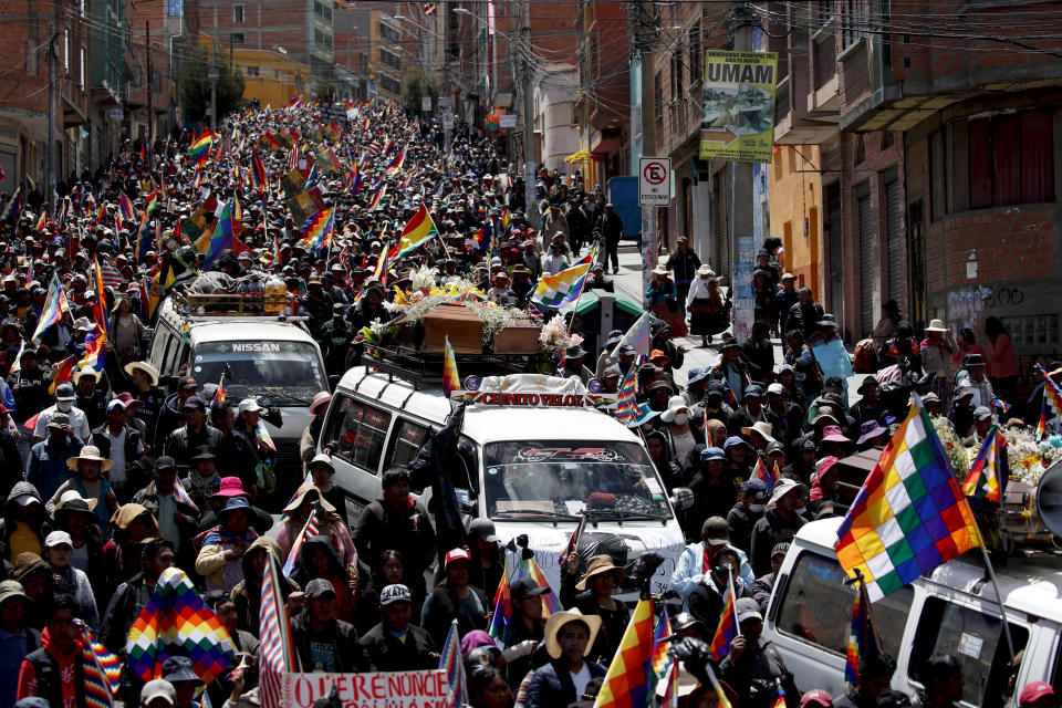 Anti-government demonstrators accompany the coffins that contain the remains of people killed in clashes between supporters of former President Evo Morales and security forces, in a funeral procession into La Paz, Bolivia, Thursday, Nov. 21, 2019. At least eight people were killed Tuesday when security forces cleared a blockade of a fuel plant by supporters of former President Evo Morales at protesters in the city of El Alto. (AP Photo/Natacha Pisarenko)