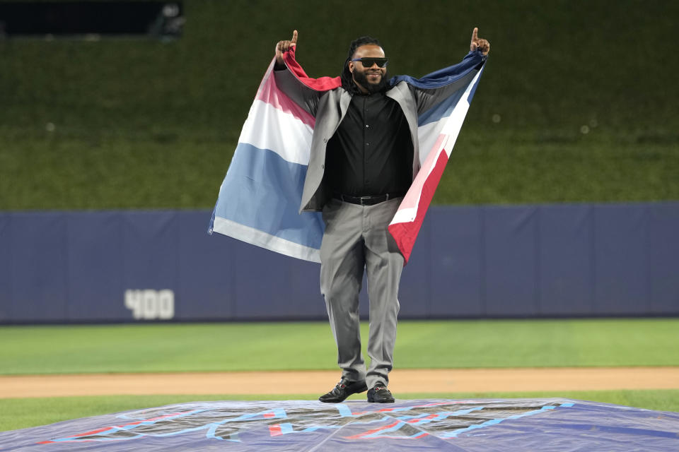 Pitcher Johnny Cueto waves from the pitching mound with the flag of the Dominican Republic after signing with the Miami Marlins baseball team, Thursday, Jan. 19, 2023, in Miami. Cueto signed a one-year contract with the Marlins with a club option for 2024. (AP Photo/Lynne Sladky)