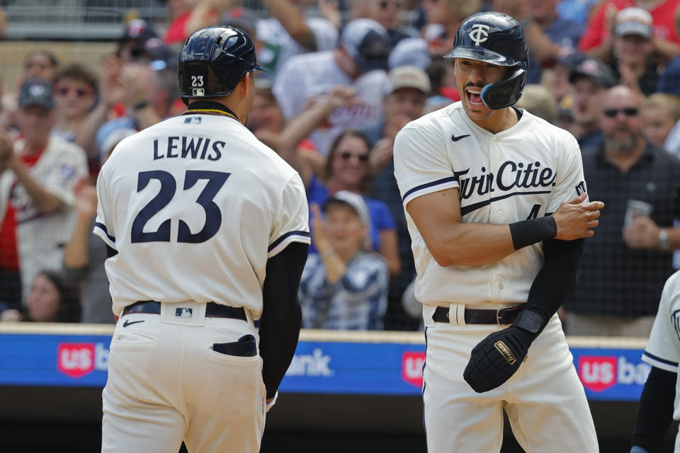 Minnesota Twins' Carlos Correa, right, greets Royce Lewis who hit a grand slam against the Texas Rangers in the sixth inning of a baseball game Sunday, Aug. 27, 2023, in Minneapolis. The Twins won 7-6 in 13 innings. (AP Photo/Bruce Kluckhohn)