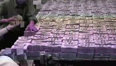 Police pile stacks of money after a raid at the home belonging to Chinese businessman Zhenli Ye Gon in Mexico City, Mexico is seen in this still image taken from video, in March 2007. Mexican Attorney General/Handout via REUTERS