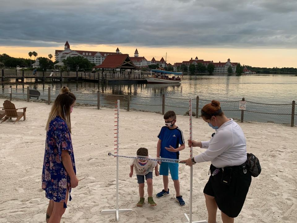 kids playing limbo on a beach at Polynesian resort disney world