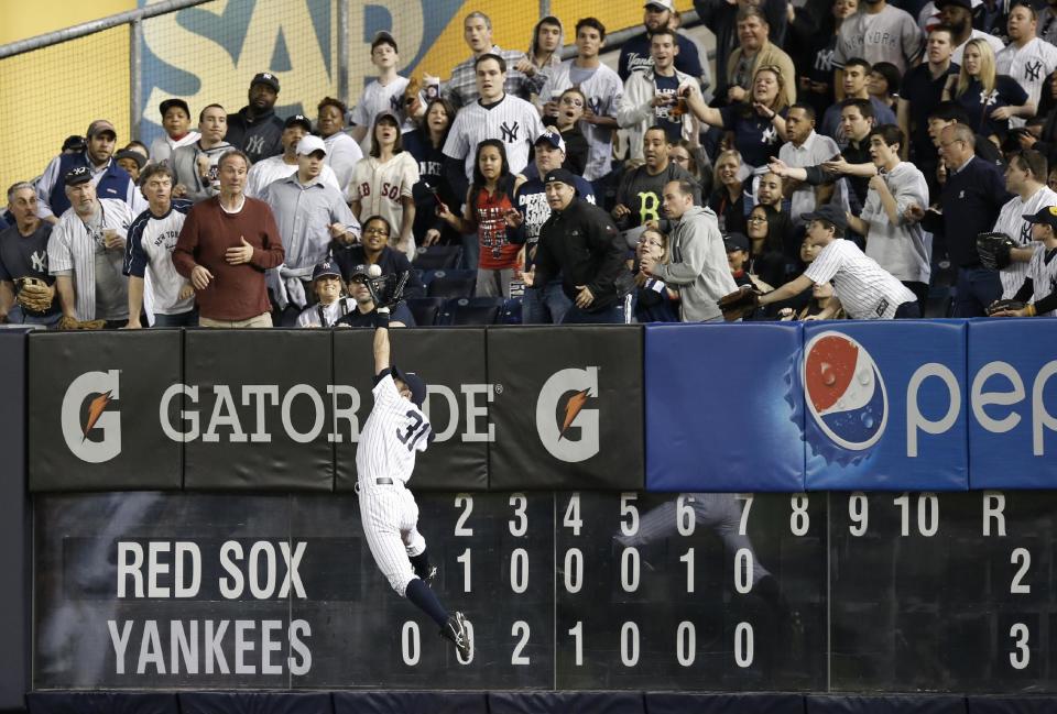 Baseball fans watch as New York Yankees right fielder Ichiro Suzuki (31) catches an eighth-inning flyout by Boston Red Sox designated hitter David Ortiz, robbing Ortiz of a game-tying home run, in the MLB American League baseball game at Yankee Stadium in New York, Sunday, April 13, 2014. (AP Photo/Kathy Willens)