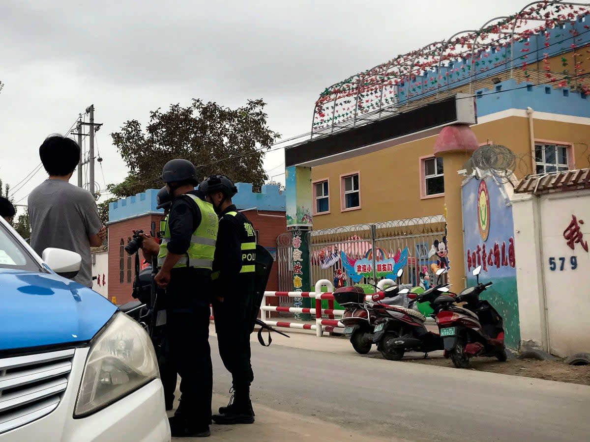 File photo: Security inspect camera equipment of journalists outside the Hotan City Kindness Kindergarten (AP)