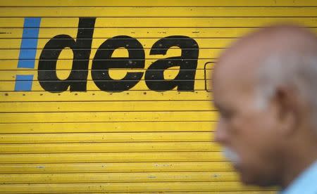 A man walks past a shop displaying Idea Cellular Ltd's logo on its shutters in Mumbai April 28, 2014. REUTERS/Danish Siddiqui/Files