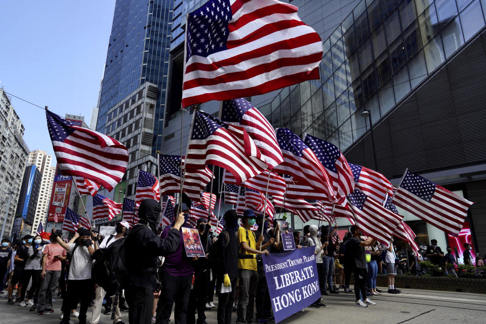 Protesters carry U.S. flags during a rally in Hong Kong, Sunday, Sept. 15, 2019. Thousands of Hong Kong people chanted slogans and marched Sunday at a downtown shopping district in defiance of a police ban, with shops shuttered amid fears of renewed violence in the months-long protests for democratic reforms in the semi-autonomous Chinese territory. (AP Photo/Vincent Yu)