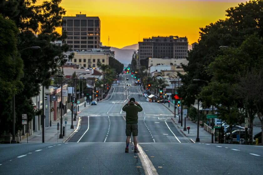 Pasadena, CA - January 01: First time since 1945, the Rose Parade in Pasadena has been cancelled due to COVID-19 pandemic. Jim Safford stops by to take a photo of deserted Colorado Blvd. on Friday, Jan. 1, 2021 in Pasadena, CA. (Irfan Khan / Los Angeles Times)