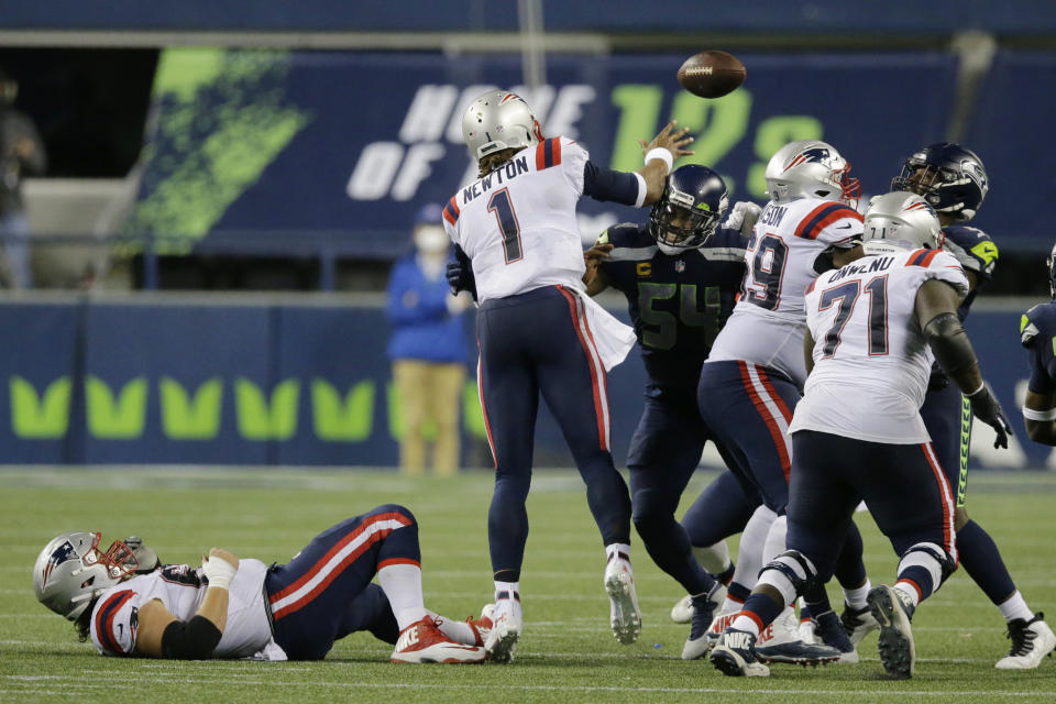 New England Patriots quarterback Cam Newton (1) passes under pressure from Seattle Seahawks middle linebacker Bobby Wagner (54) during the second half of an NFL football game, Sunday, Sept. 20, 2020, in Seattle. The Seahawks won 35-30. (AP Photo/John Froschauer)