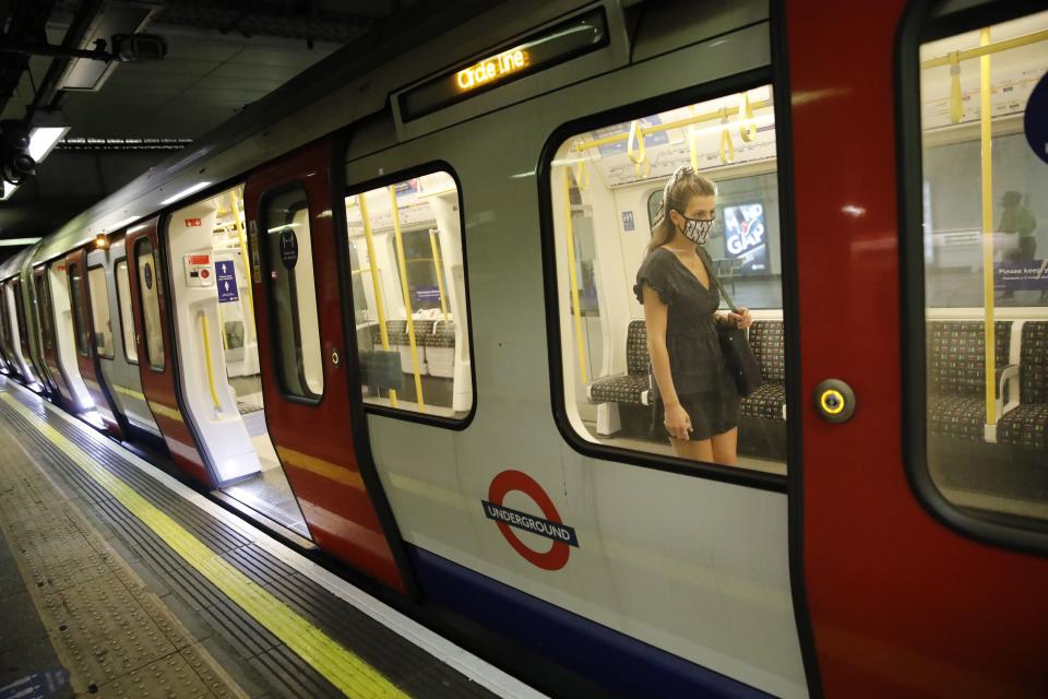 A passenger wears a face mask as a precaution against the transmission of the novel coronavirus as she boards a London Underground tube train in London on July 17, 2020. - Boris Johnson said on July 17 he hoped Britain would "return to normality" by November despite being badly affected by the coronavirus and predictions of a second wave of cases during winter months. Johnson sketched out a timetable for easing the remaining lockdown measures in England, including lifting homeworking guidance and reopening sports stadiums and live theatre. (Photo by Tolga AKMEN / AFP) (Photo by TOLGA AKMEN/AFP via Getty Images)