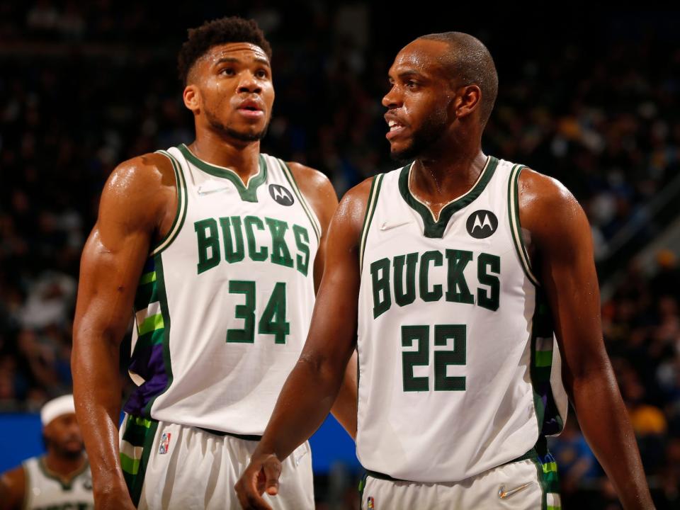 Giannnis Antetokounmpo looks up while Khris Middleton walks by him during a game.