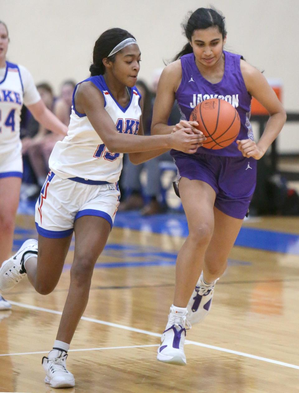 Serenitee Johnson (left) of Lake knocks the ball away from Leena Patibandla (right) of Jackson during their game at Lake on Wednesday.