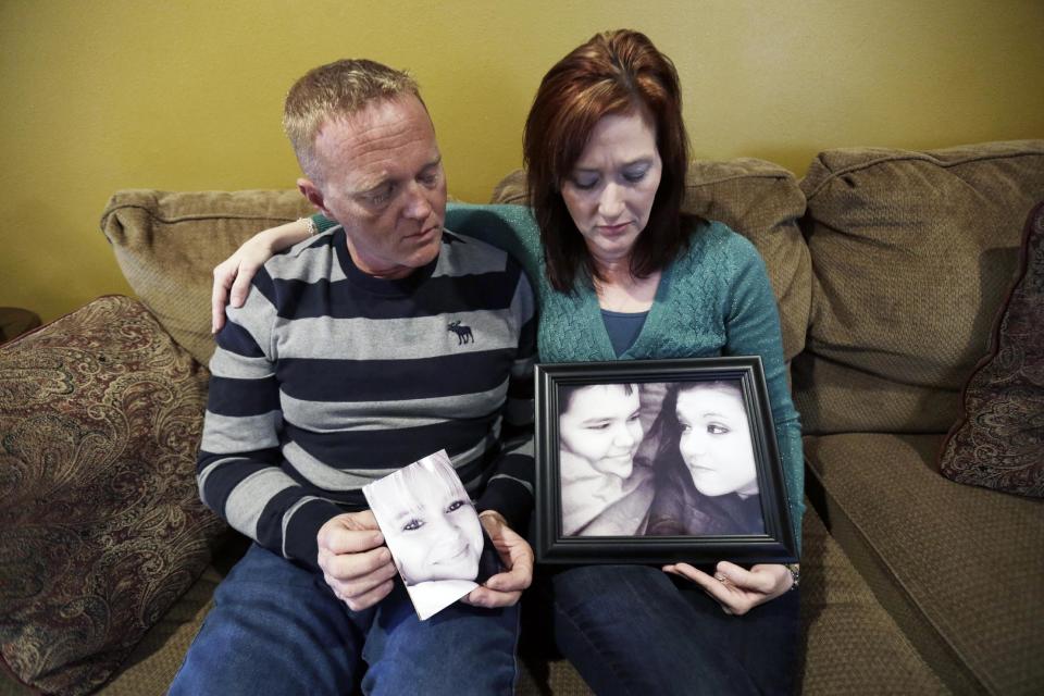 Kainan and Jessica McAllister pose with family photos of Kainan's sister Denise Freeman and her children Kacie and Joshua, during an interview with The Associated Press in Chalmette, La., Friday, Jan. 10, 2014. Denise was the first victim in the killing spree at the hands of her husband, Benjamin Freeman. The shootings stunned the bayou community 50 miles southwest of New Orleans. Investigators, victims and grieving family members don’t know exactly what set off Freeman’s rampage. But the shootings raised concerns about whether Louisiana law provides adequate safeguards to keep guns away from troubled people. (AP Photo/Gerald Herbert)