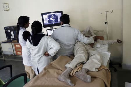 Doctors look at the ultrasound scan of a patient at Janakpuri Super Speciality Hospital in New Delhi January 19, 2015. REUTERS/Adnan Abidi