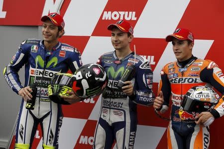 Yamaha MotoGP rider Jorge Lorenzo (C) of Spain poses with Yamaha MotoGP rider Valentino Rossi (L) of Italy and Honda MotoGP rider Marc Marquez of Spain after winning the pole position for Sunday's Japanese Grand Prix after a qualifying session at the Twin Ring Motegi circuit in Motegi, north of Tokyo, Japan, October 10, 2015. REUTERS/Issei Kato