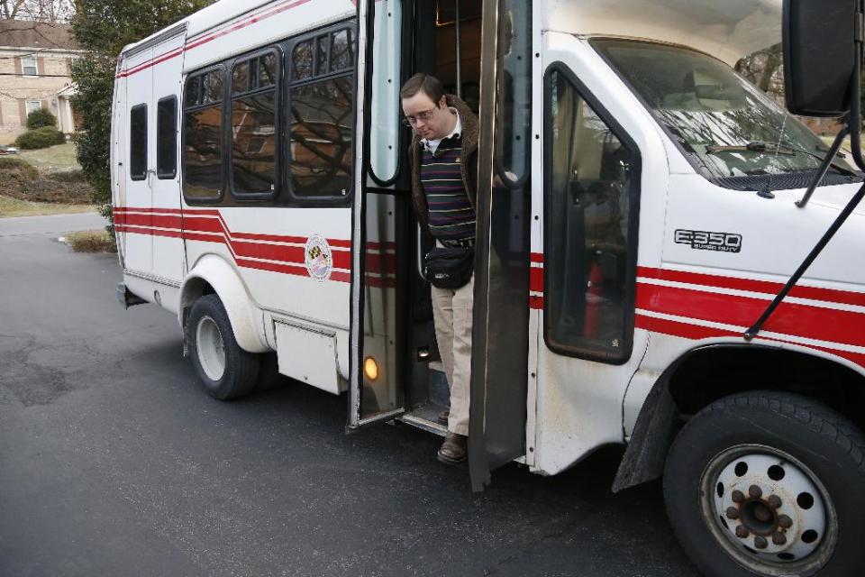 This photo taken Feb. 10, 2014 shows Matthew McMeekin getting off a bus at his home in Bethesda, Md. as he returns from work. Most Americans with intellectual or developmental disabilities remain shut out of the workforce, despite changing attitudes and billions spent on government programs to help them. Even when they find work, it’s often part time, in a dead-end job or for pay well below the minimum wage. McMeekin, 35, of Bethesda, Md., has spent 14 years working at Rehabilitation Opportunities Inc., a nonprofit sheltered workshop where he and other disabled workers are bused each workday to stuff envelopes, collate files or shrink-wrap products _ all for far less than the state minimum wage of $8.25 an hour. (AP Photo/Charles Dharapak)