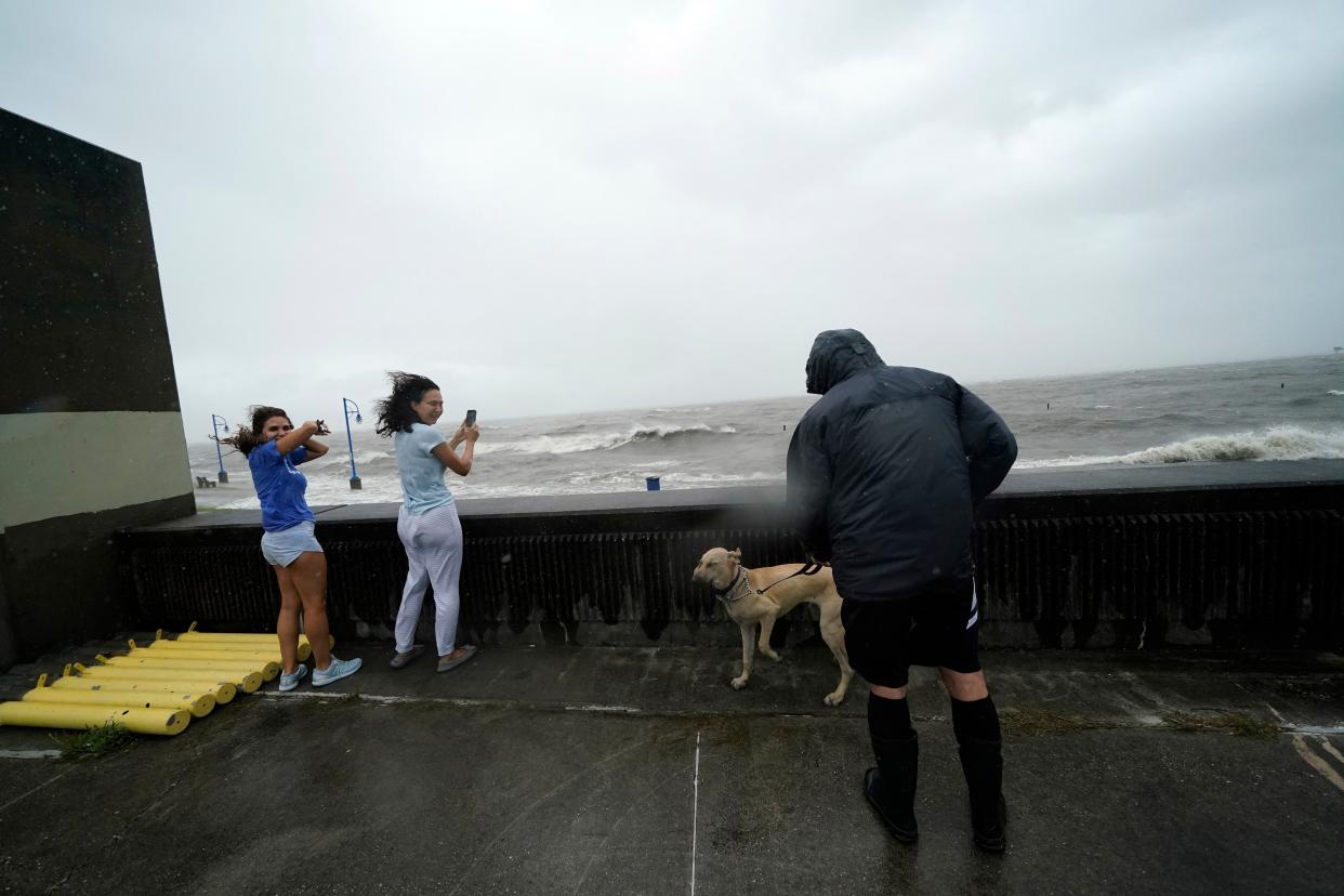 Liliana Arias, left, and Cristina Burgos take photos of the rough waters of Lake Pontchartrain in advance of approaching Hurricane Ida in New Orleans on Sunday, Aug. 29, 2021.